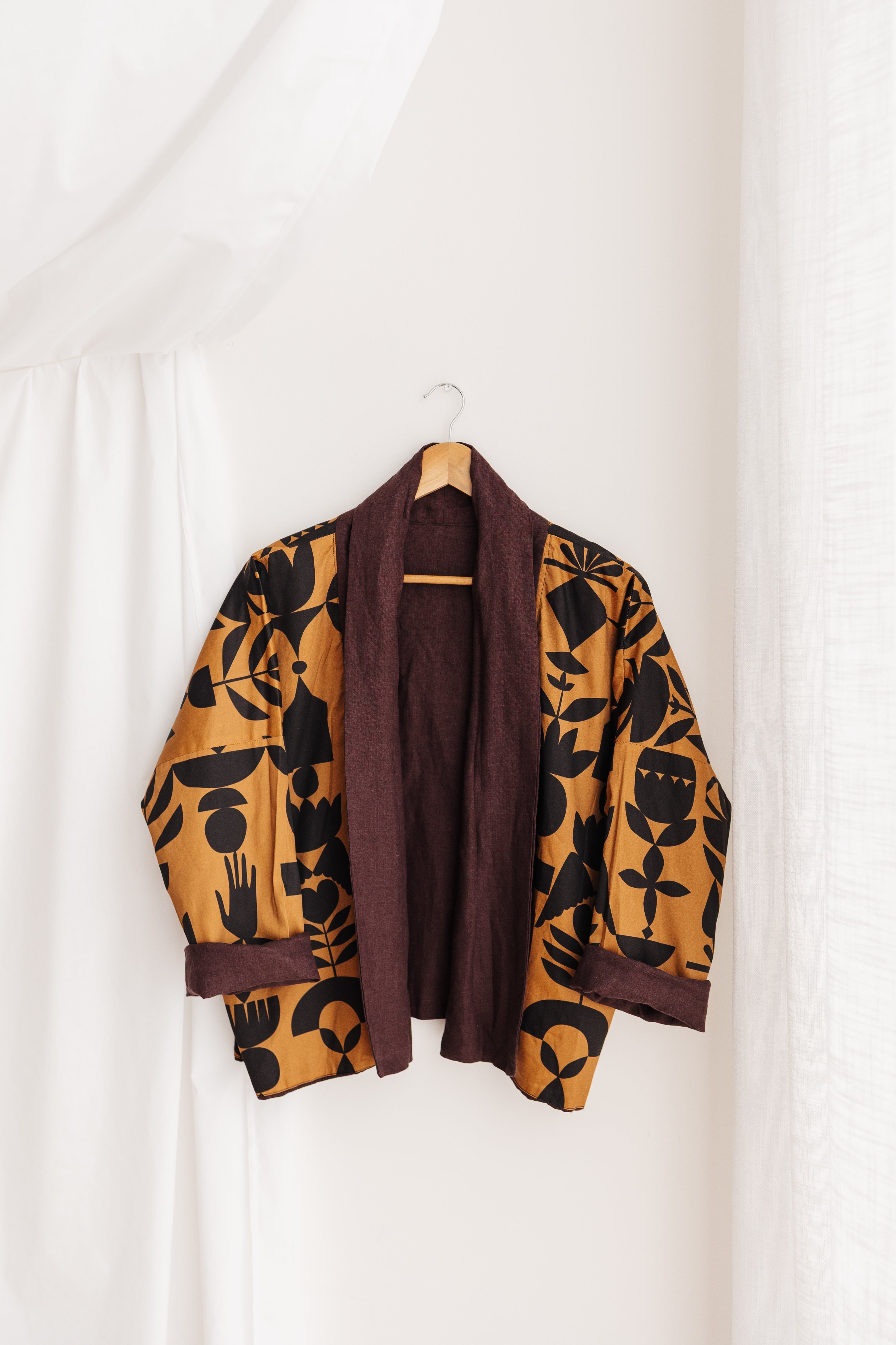 A reversible linen jacket — two looks in one. Butterscotch Memento print by Cecilia Mok and rich aubergine linen. Handmade in the Dandenong Ranges, Australia.